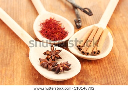 Fragrant spices in wooden spoons on a wooden background close-up