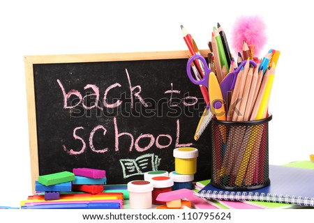 The words 'Back to School' written in chalk on the small school desk with various school supplies close-up isolated on white