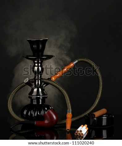 Smoking tools - a hookah, cigar, cigarette and pipe on black background