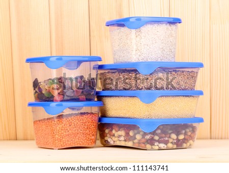 Filled plastic containers on wooden background