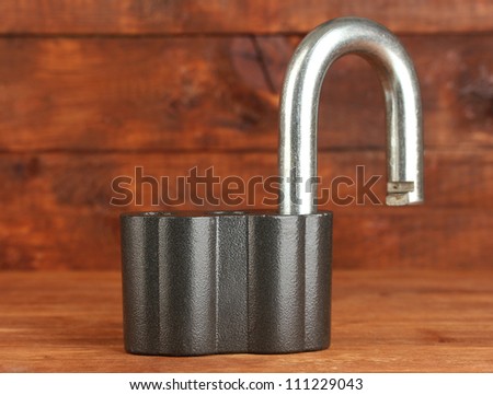 old padlock on wooden background close-up