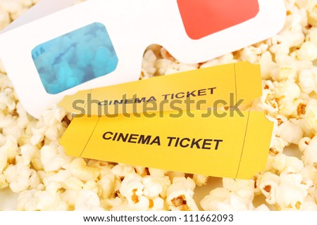 cinema tickets and glasses on popcorn background