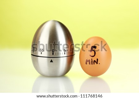 egg timer and egg on green background