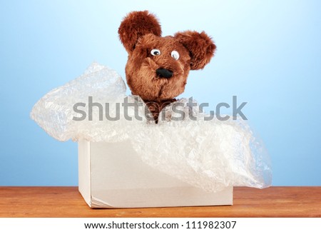 Opened parcel with a child\'s toy on blue background close-up