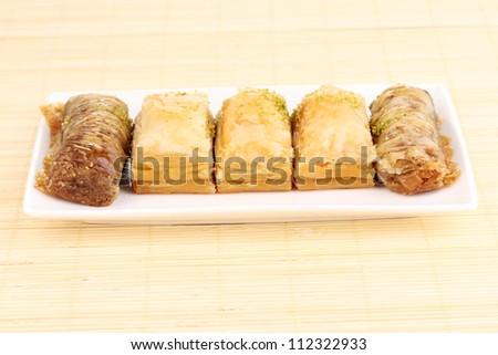 Sweet baklava on plate on bamboo mat