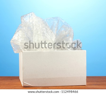 Opened parcel on blue background close-up