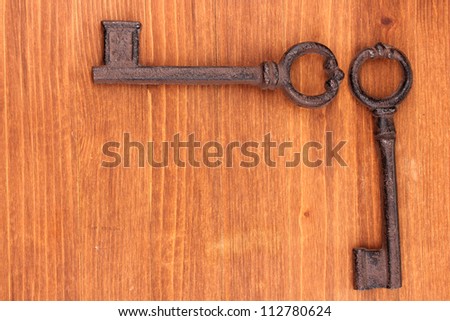 Two antique keys on wooden background