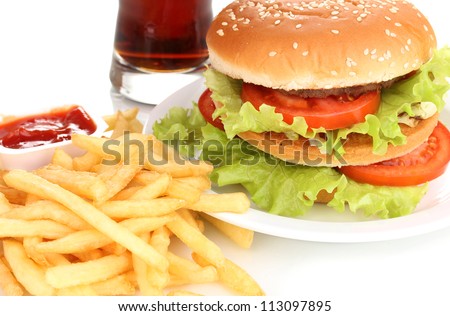 Big and tasty hamburger on plate with cola and fried potatoes close-up