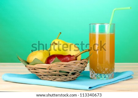 Pear juice with pears on wooden table on blue background