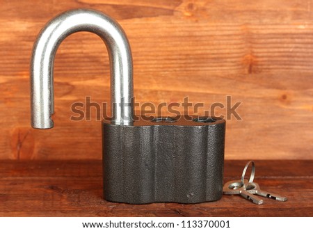old padlock with keys on wooden background close-up