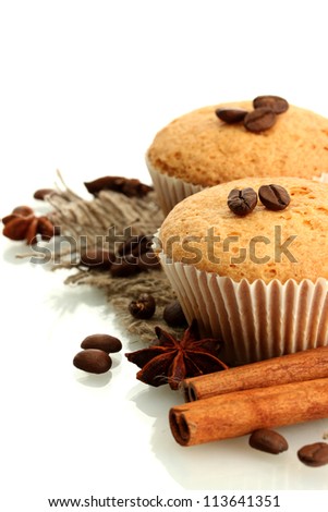 tasty muffin cakes on burlap, spices and coffee seeds, isolated on white