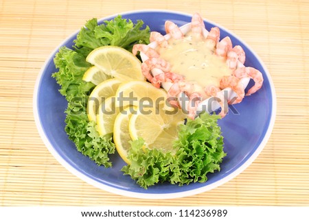 Delicious marinated shrimp with sauce served on plate on bamboo mat