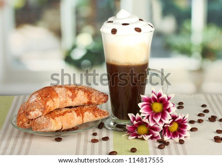 glass of fresh coffee cocktail and saucer with bagels on the table