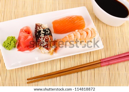 delicious sushi served on plate on bamboo mat