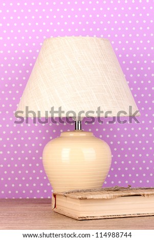 table lamp and book on purple polka dot background