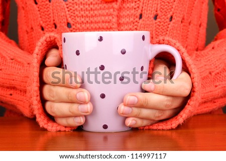 hands holding mug of hot drink close-up