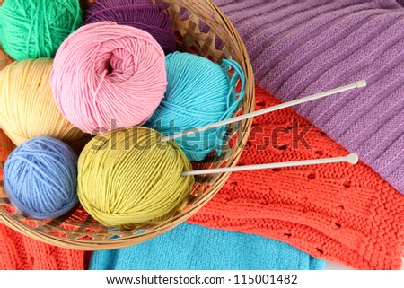 colorful wool sweaters and balls of wool close-up