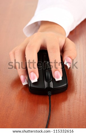woman\'s hands pushing keys of pc mouse, on wooden table close-up