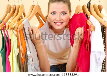 beautiful young woman near rack with hangers