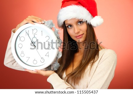 beautiful young woman with clock, on red background