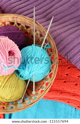 colorful wool sweaters and balls of wool close-up