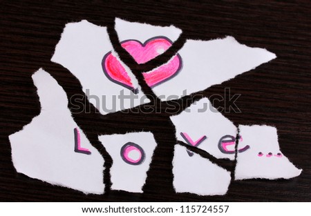 Torn paper with words Love close-up on wooden table