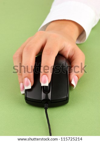 woman\'s hands pushing keys of pc mouse, on green background close-up