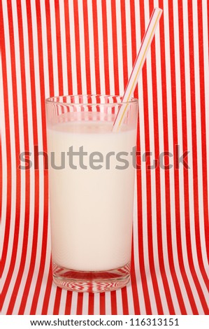 Glass of fresh new milk on red striped background