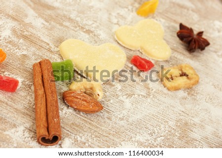 candied fruit, nuts, unbaked biscuits and molds for cookies on a wooden table close-up