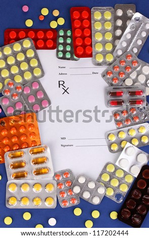 Capsules and pills packed in blisters with prescription pharmacist on blue background