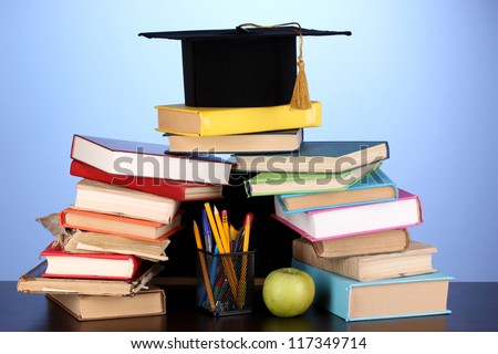 magister cap against wooden table books background shutterstock
