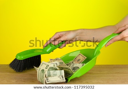 Sweeps money in the shovel on colorful background close-up