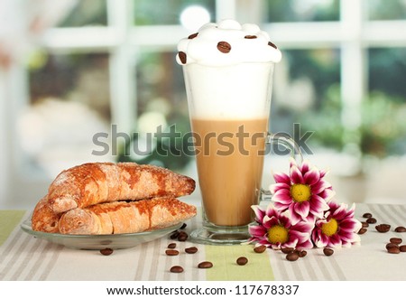 glass of fresh coffee cocktail and saucer with bagels on the table