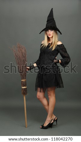 Halloween witch with  broom on gray background