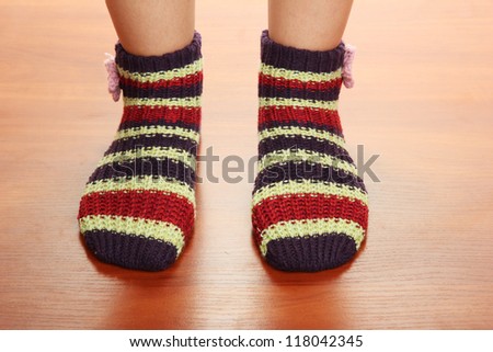 Legs female in striped socks on laminate floor