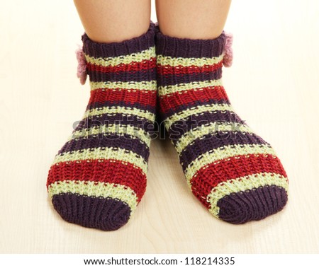 Legs female in striped socks on laminate floor