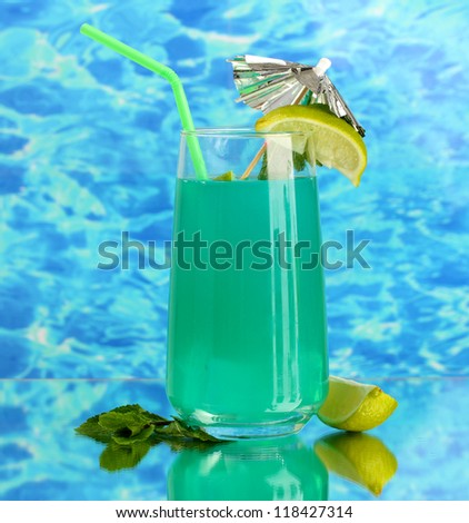 Glass of blue cocktail on blue background