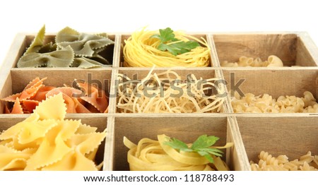 Nine types of pasta in wooden box sections close-up isolated on white
