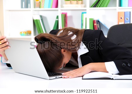 Tired business woman with notebook in her workplace