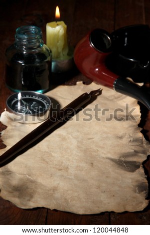 Old paper with ink pen, compass and cigar near lighting candle on wooden table