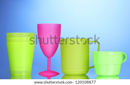 Bright plastic tableware on blue background