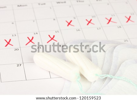 menstruation calendar with sanitary pads and tampons, close-up
