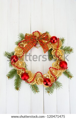 christmas wreath of dried lemons with fir tree and balls, on wooden background