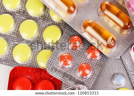 Capsules and pills packed in blisters close-up background