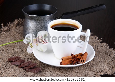 White cup of Turkish coffee with coffee maker on wooden table