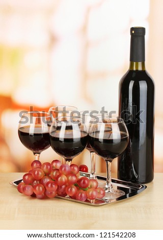 Red wine in glass and bottle on room background