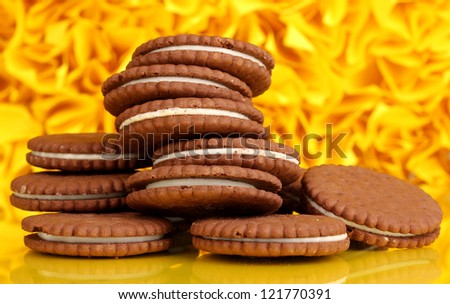 Chocolate cookies with creamy layer on yellow decorative background