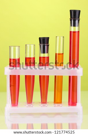 Test-tubes with a colorful solution on green background close-up