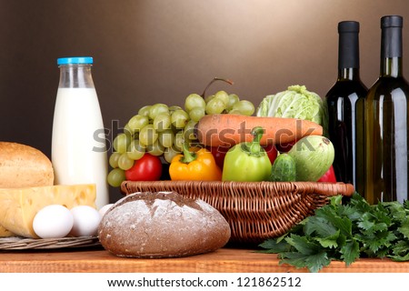 Composition with vegetables  in wicker basket on brown background