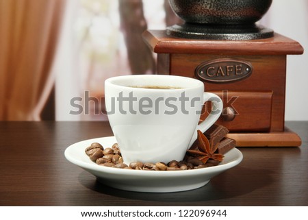 cup of coffee, grinder and coffee beans in cafe